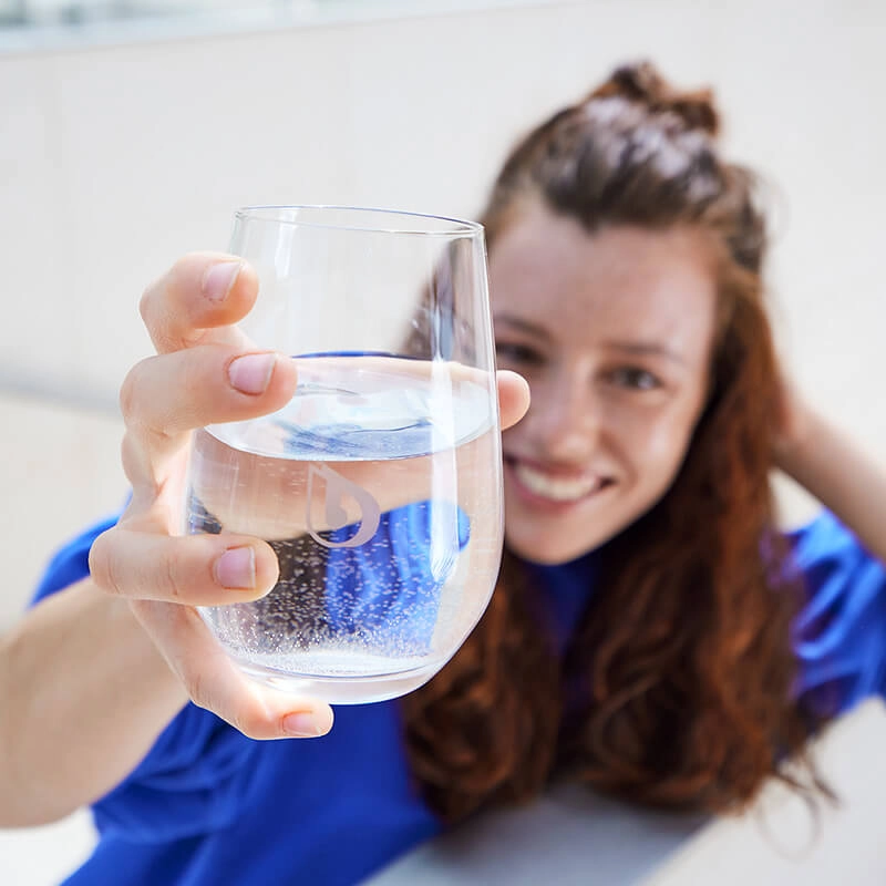 Bestes Wasser zum Trinken Frau zeigt BWT Wasserglas