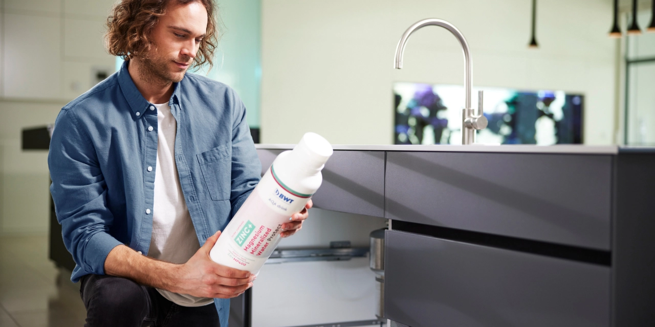 BWT filter cartridge against lead and copper Man installs filter cartridge