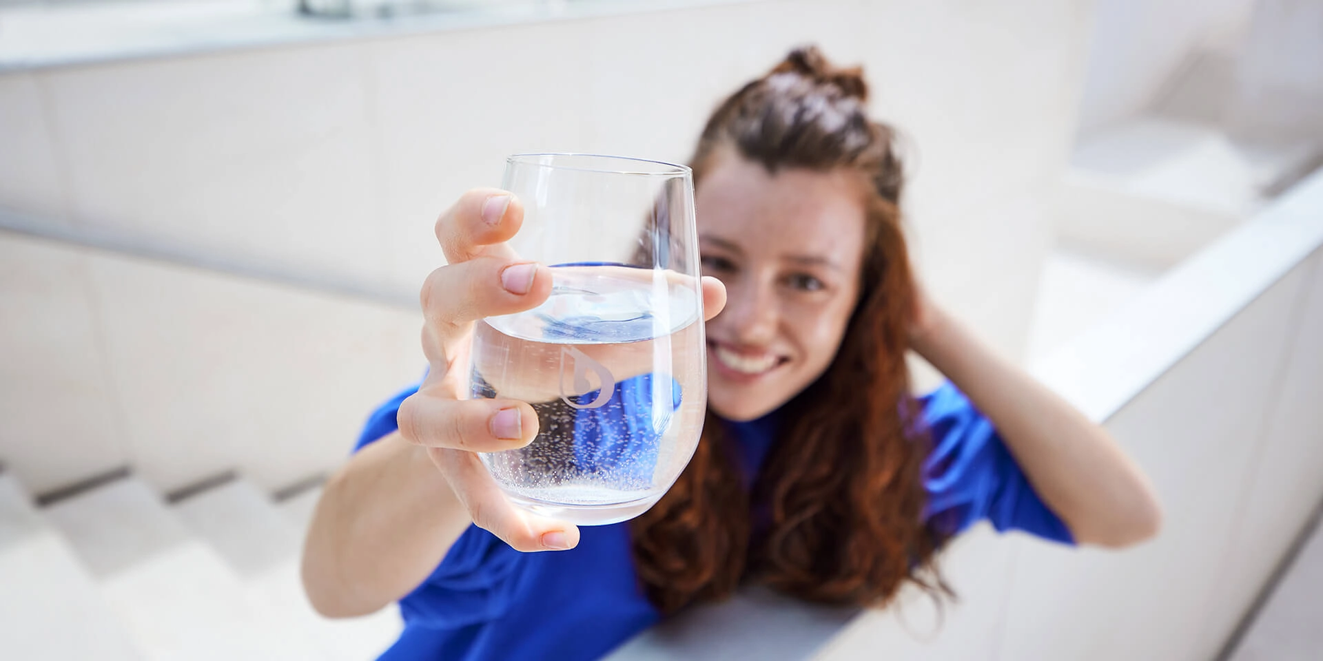 Bestes Wasser zum Trinken Frau zeigt BWT Wasserglas