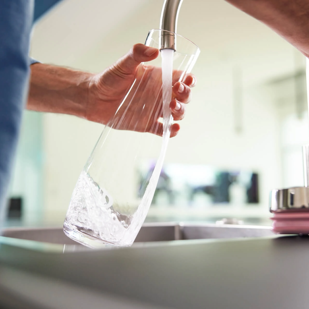 Karaffe mit Wasser füllen am Wasserhahn