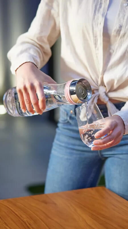 Pouring BWT Water from Glass Carafe into Glass